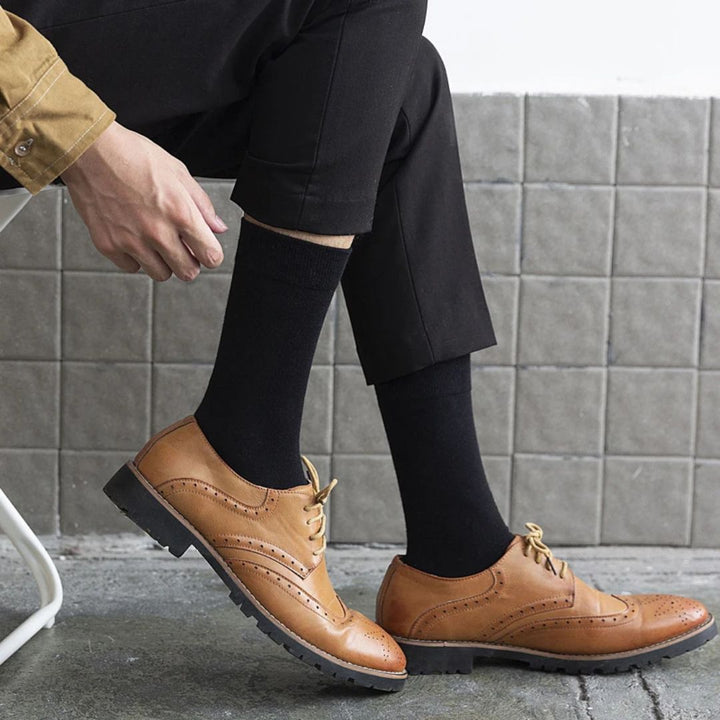 Herren Brogues Schuhe, braunes Leder, elegantes Design, schwarze Socken, Business-Look.
