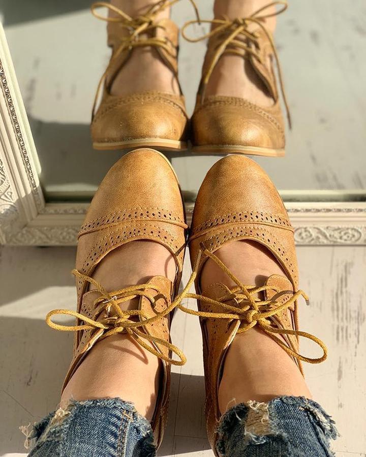 Braune Leder-Brogues für Damen, geschnürt, Vintage-Stil, reflektiert im Spiegel.