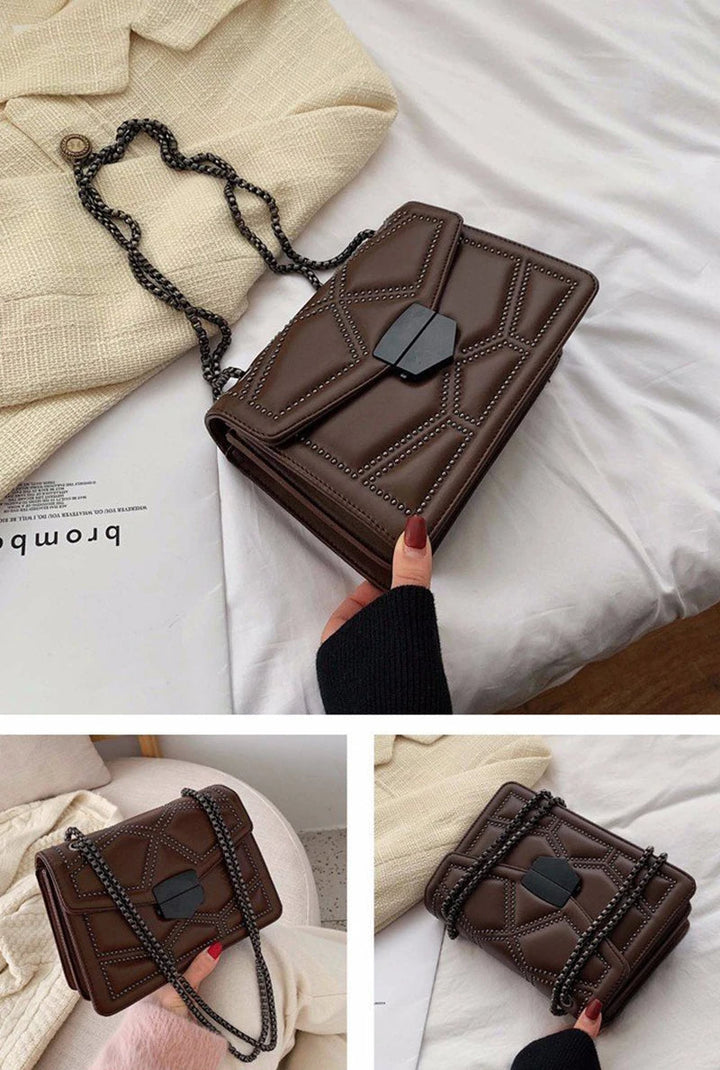 Dunkelbraune Damenhandtasche mit Kettengurt auf beigem Stoff, stilvoll und elegant.