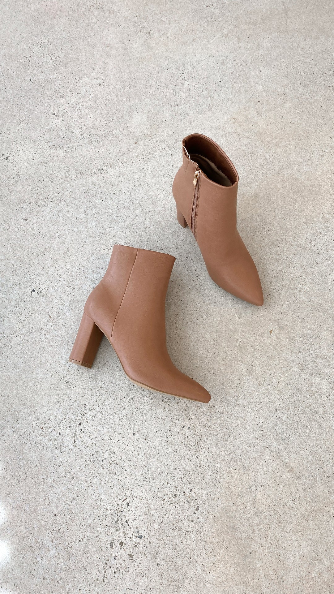 Braune Damen-Stiefeletten mit Blockabsatz, Reißverschluss, Lederoptik, auf Betonboden.