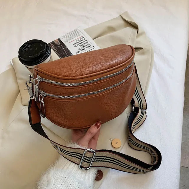 Braune Damen-Umhängetasche aus Leder mit breitem Schulterriemen und Reißverschlüssen.