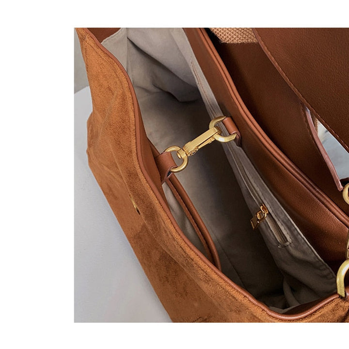 Braune Wildledertasche mit goldenen Details, Innenfächer, stilvoll, elegant, Damenmode.