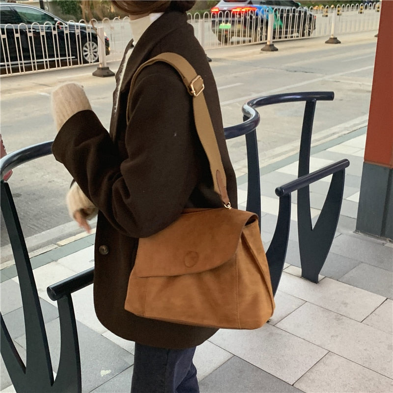 Frau mit brauner Wildledertasche, lässiger Stil, Straßenhintergrund, Herbstmode.