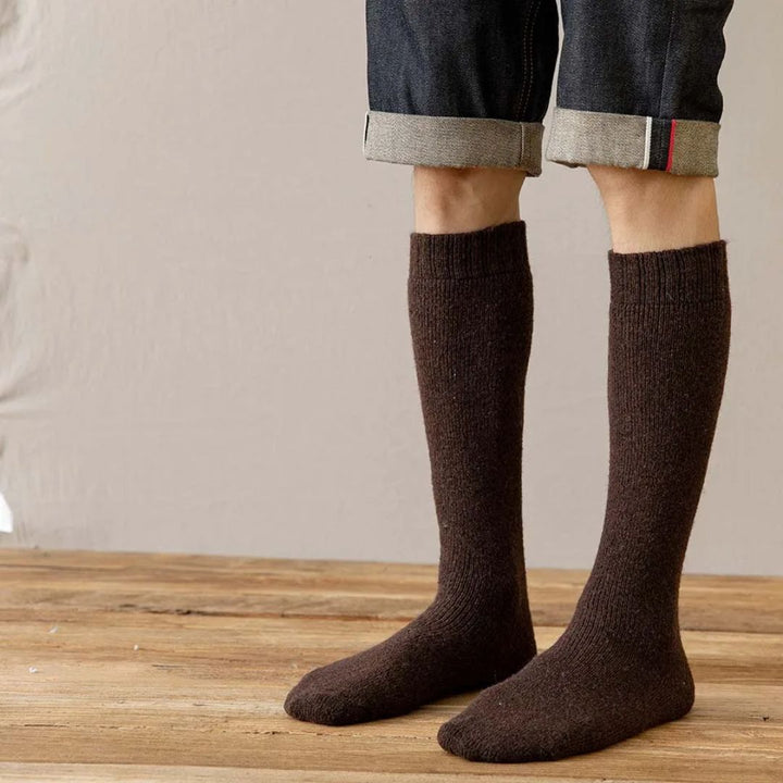 Braune Wollsocken, knielang, unisex, warm, bequem, ideal für Herbst und Winter, auf Holzboden.