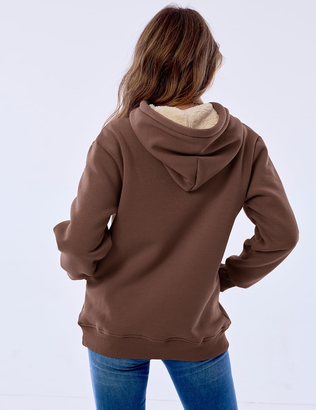 Frau in braunem Kapuzenpullover aus Baumwolle, Rückansicht, lässige Mode, Herbstbekleidung.