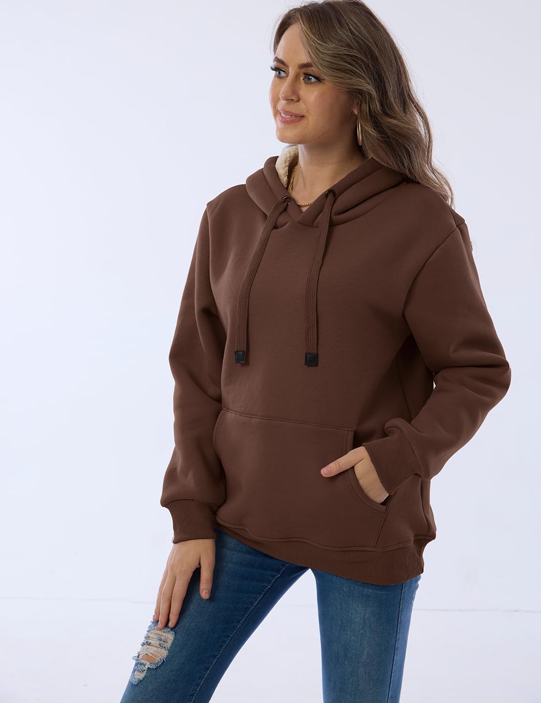 Frau in braunem Kapuzenpullover aus Baumwolle, lässig, mit Kängurutasche, modisch, bequem.