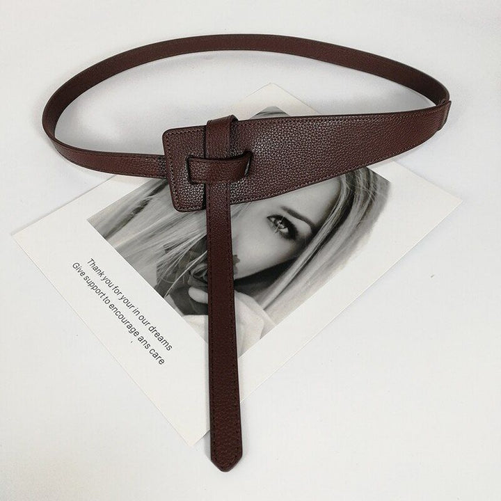Brauner Ledergürtel mit Knoten-Design auf Schwarz-Weiß-Foto, modisches Accessoire.