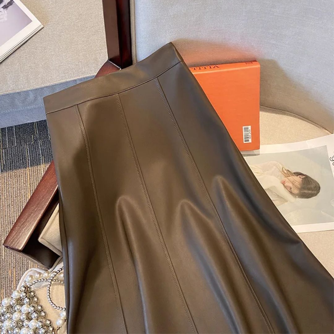 Brauner Lederrock auf Stuhl, elegante Damenmode, stilvoller Look, Herbst-Winter-Kollektion.