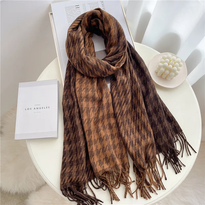 Brauner Hahnentritt-Schal aus Wolle auf Tisch, modisches Accessoire, Herbst-Winter-Trend.