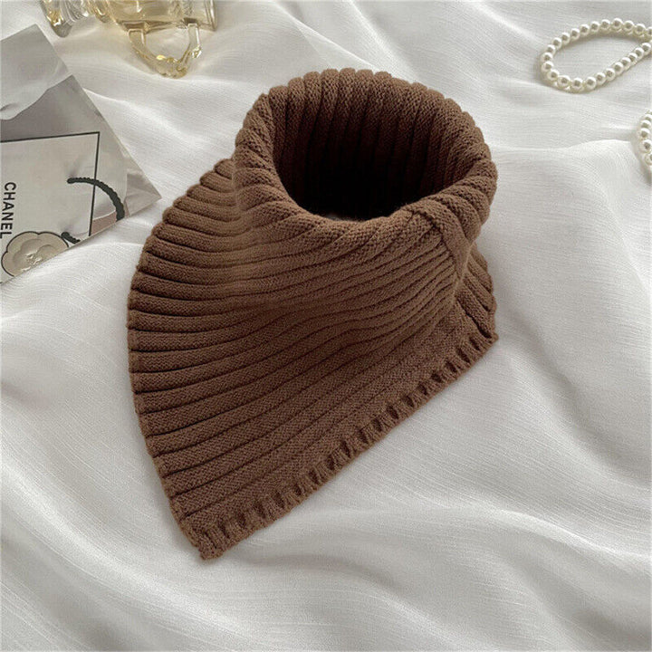 Brauner Strickschal auf weißem Stoff, modisches Accessoire, Herbst-Winter, Damenmode.