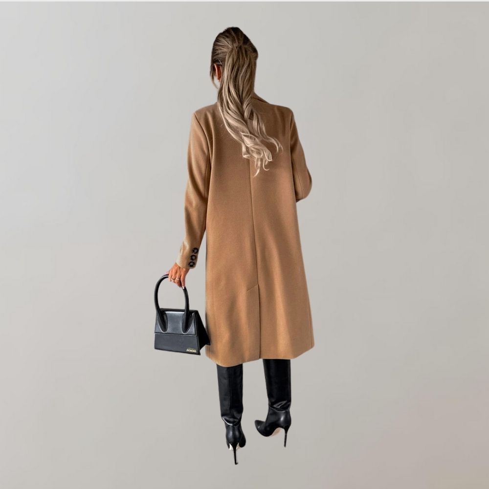 Frau in braunem Wintermantel, schwarze Stiefel, schwarze Handtasche, eleganter Damenlook.