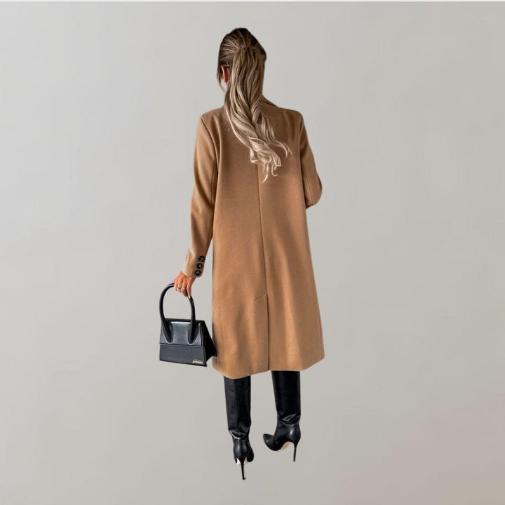 Frau in braunem Wintermantel, schwarze Stiefel, schwarze Handtasche, eleganter Damenlook.