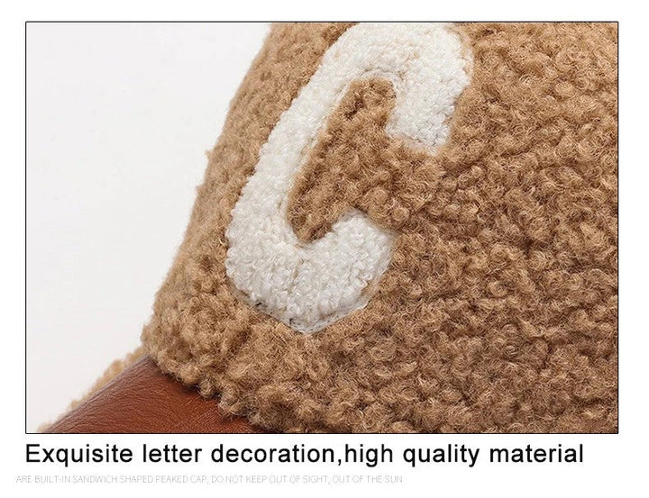 Braune Wollmütze mit weißem Buchstaben "C", weiches Material, modisches Accessoire.