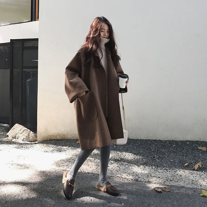 Frau im braunen Wollmantel mit Kaffeebecher, Herbstmode, lässiger Stil, draußen spazieren.