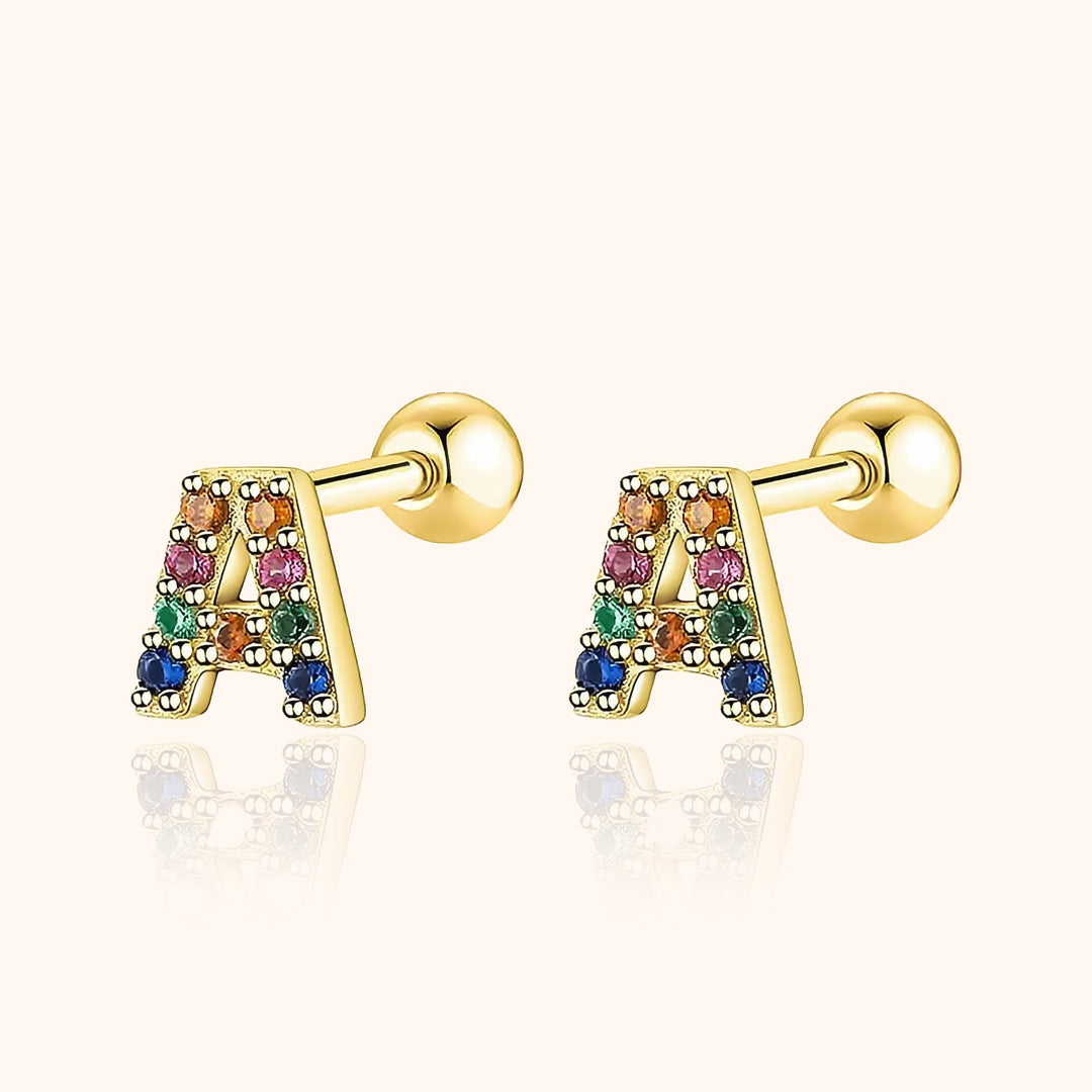 Goldene Ohrringe mit bunten Kristallen in Buchstabenform, modische Accessoires, Damen-Schmuck.