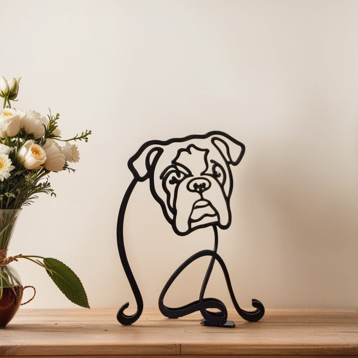 Englische Bulldogge Metallskulptur, schwarz, auf Holzregal neben Blumenstrauß.