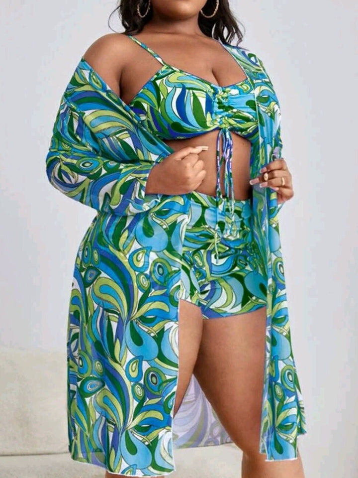 Frau in buntem, gemustertem Strandoutfit mit Kimono, Bikinioberteil und Shorts.