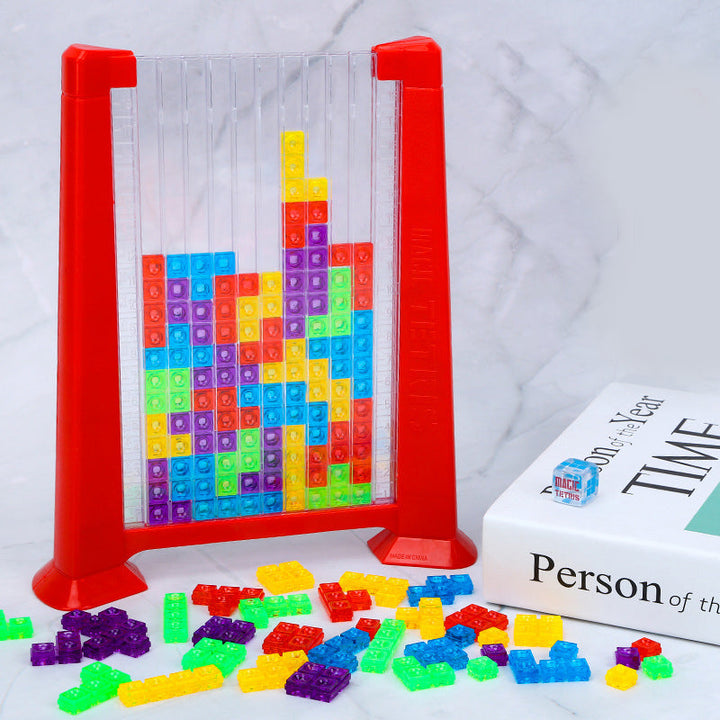 Rotes Tetris-Spielzeug aus Kunststoff mit bunten Bausteinen auf Marmortisch.