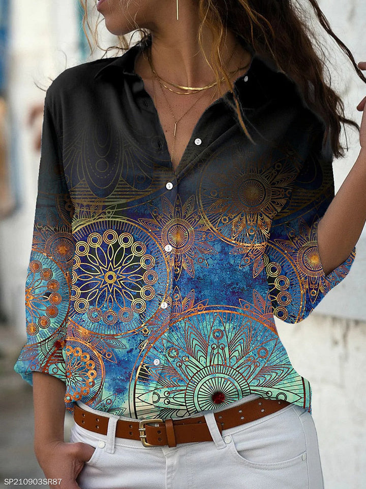 Frau in schwarzer Bluse mit Mandala-Muster, blau-grünem Farbverlauf, lässiger Stil.