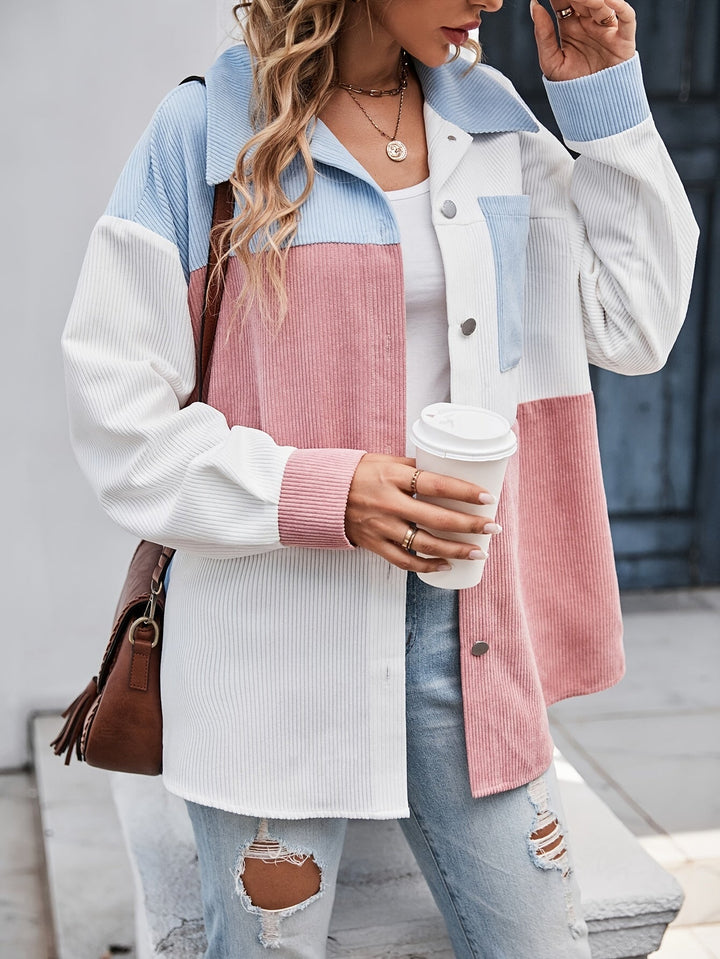 Frau in pastellfarbener Cordjacke, hält Kaffeebecher, modisch, lässig, Herbstmode.