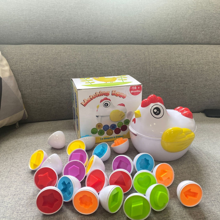 Buntes Lernspielzeug Huhn mit Formen, Kunststoff, für Kleinkinder ab 18 Monaten, auf Sofa.