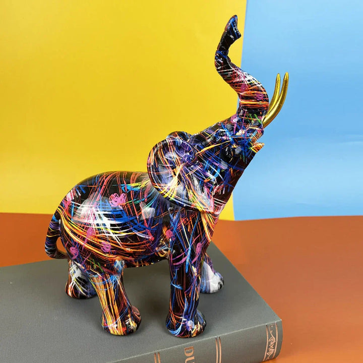 Bunte Elefantenfigur aus Harz mit abstraktem Muster, stehend auf Buch, moderne Deko.