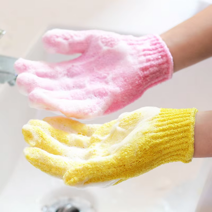 Zwei bunte Peeling-Handschuhe, rosa und gelb, beim Händewaschen mit Seifenschaum.