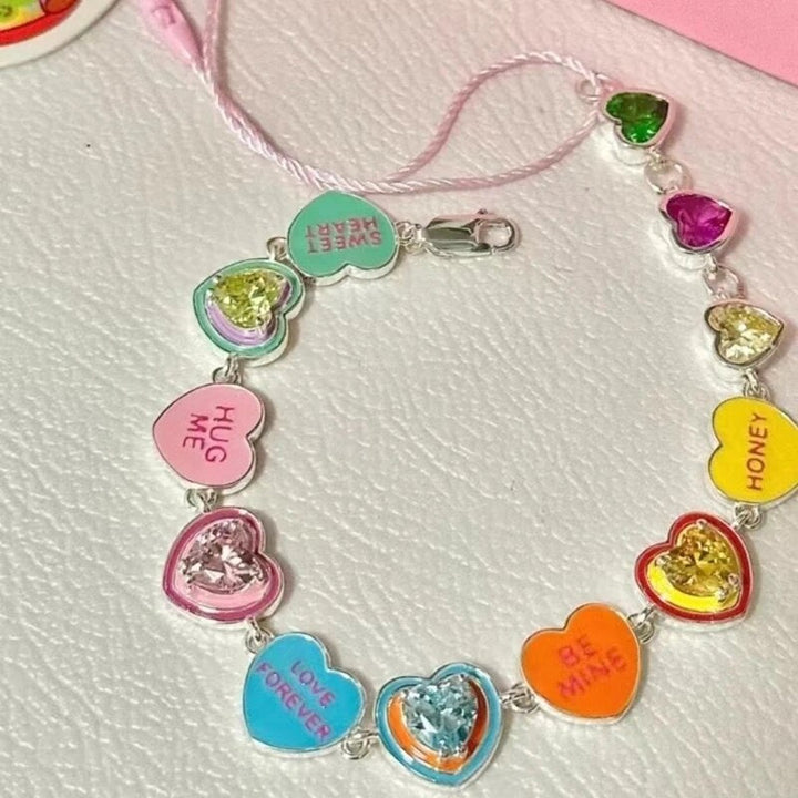 Buntes Herzarmband mit Kristallen und Liebesbotschaften, modisches Accessoire für Damen.