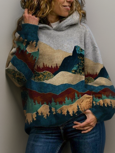 Frau in grauem Hoodie mit buntem Berg- und Waldmotiv, lässige Mode, Herbstkleidung.
