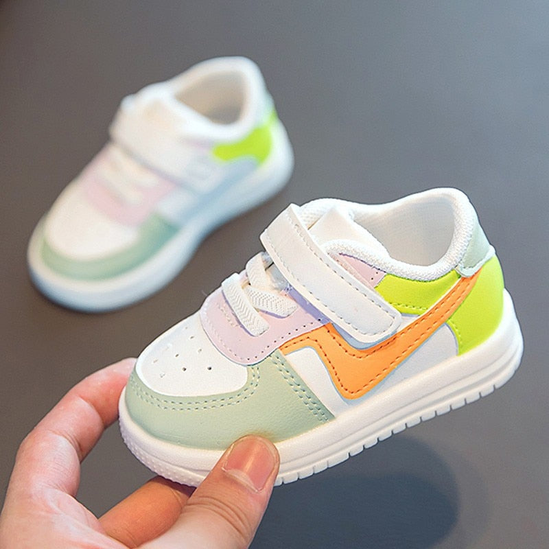 Weiße Kinderschuhe mit bunten Akzenten, Klettverschluss, sportliches Design.