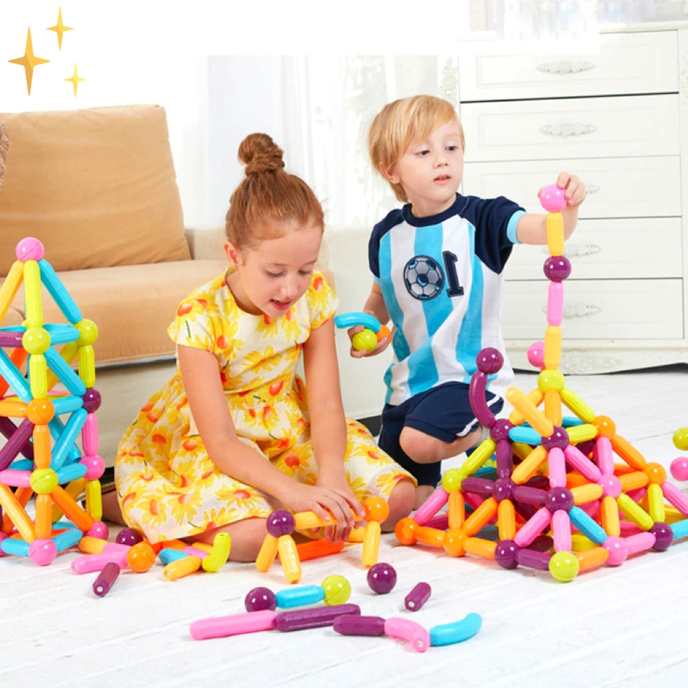 Kinder spielen mit buntem magnetischem Konstruktionsspielzeug im Wohnzimmer.