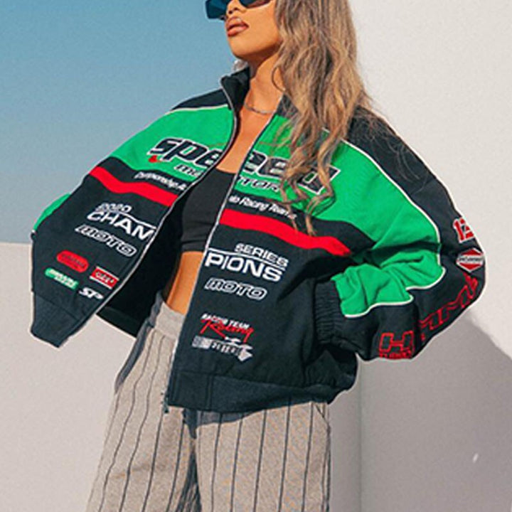 Frau in grüner und schwarzer Rennjacke, gestreifte Hose, Sonnenbrille, modisch, urban.