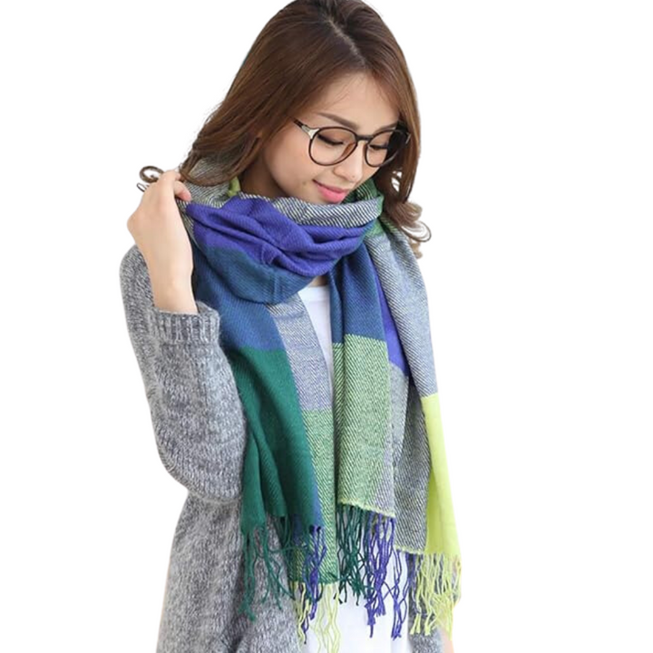 Frau mit blau-grünem kariertem Schal, Brille, grauer Strickpullover, modisches Winteroutfit.