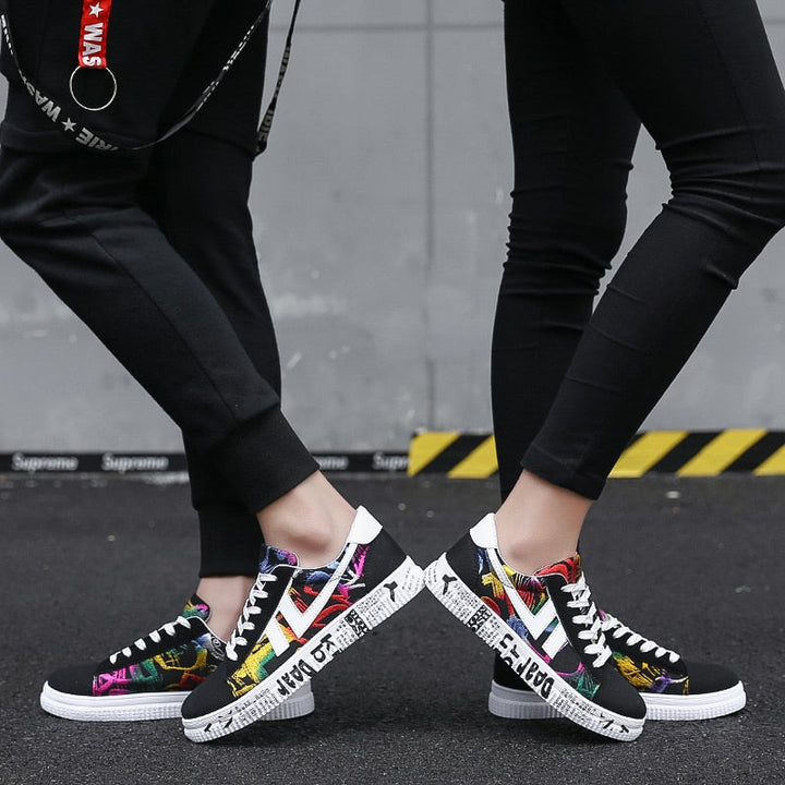 Bunte Sneaker mit Graffiti-Design, Unisex, lässig, Straßenmode, schwarze Hose, Asphalt.