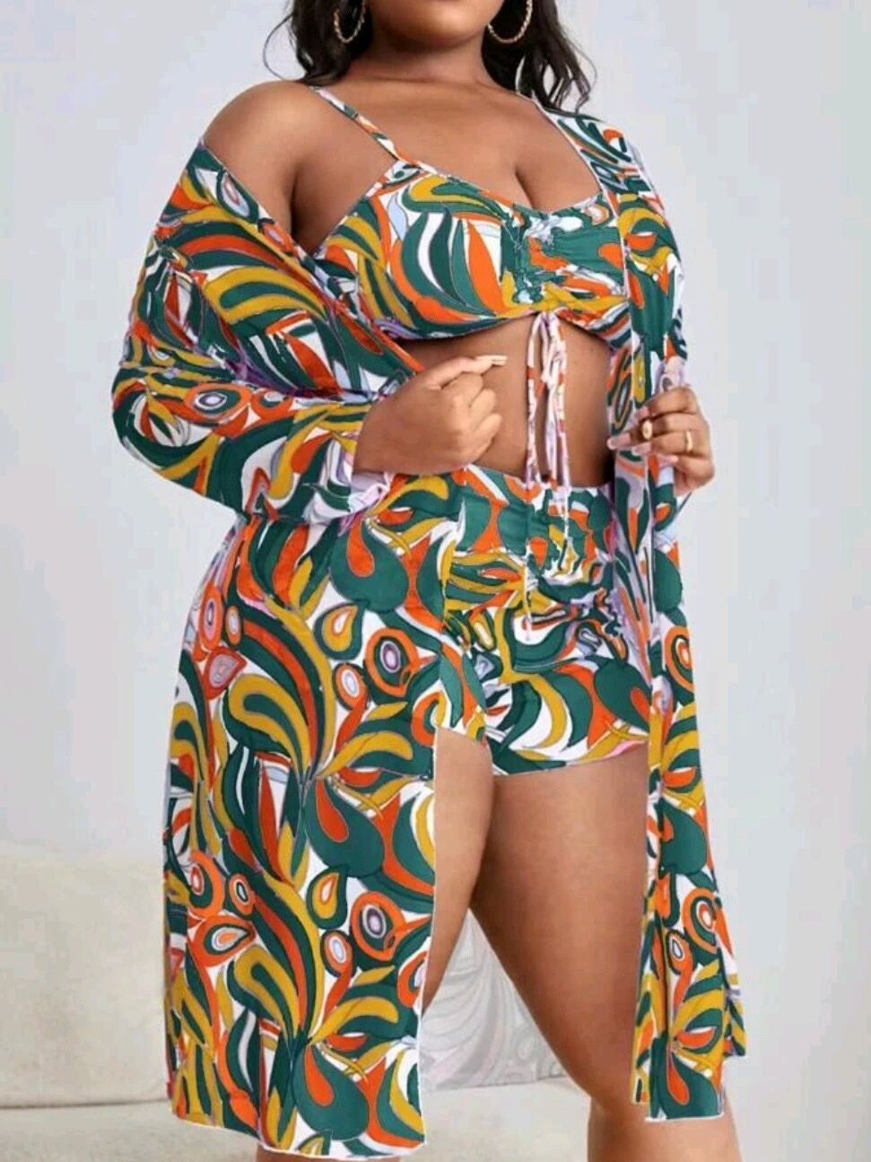 Frau in buntem, gemustertem Sommeroutfit mit Kimono, Top und Shorts.