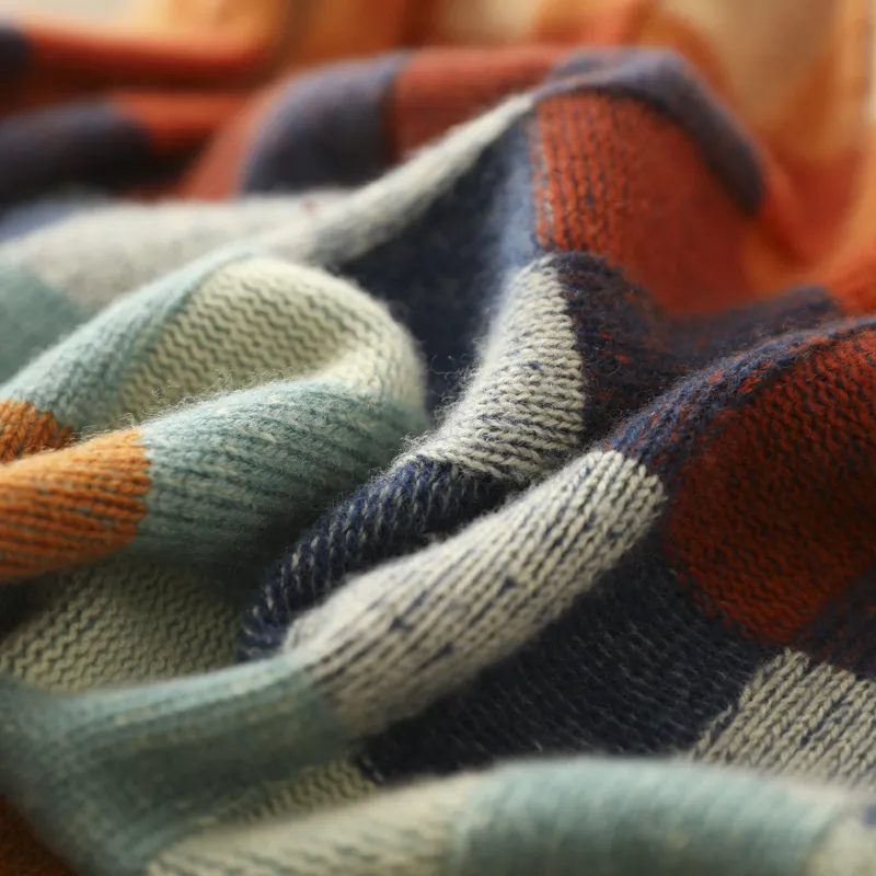 Bunte gestrickte Decke aus Wolle, kariertes Muster, weiche Textur, gemütliche Wohnaccessoires.
