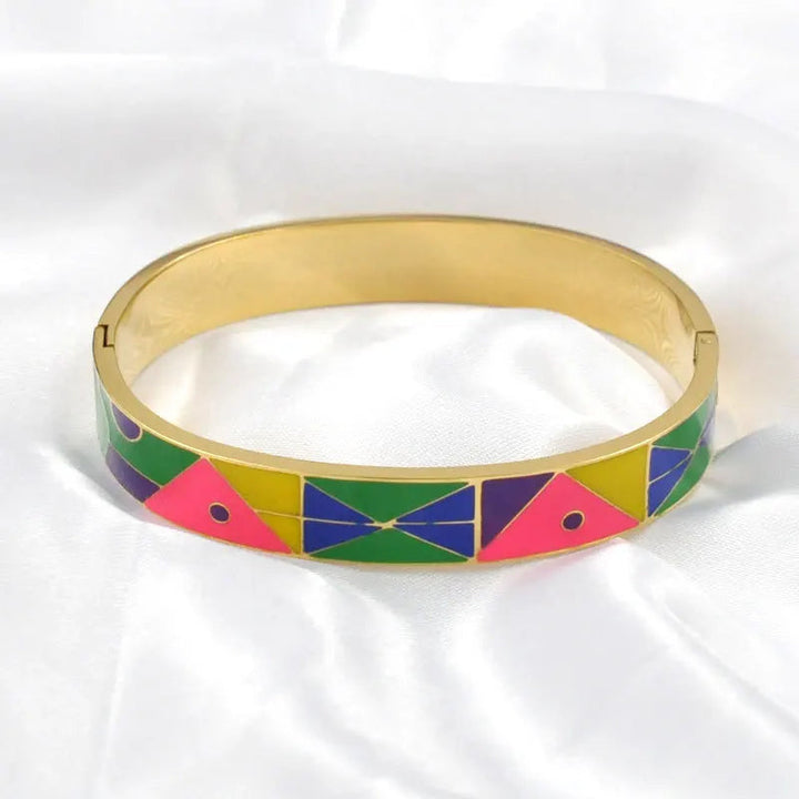 Goldenes Armband mit buntem geometrischem Muster auf weißem Hintergrund, modisches Accessoire.