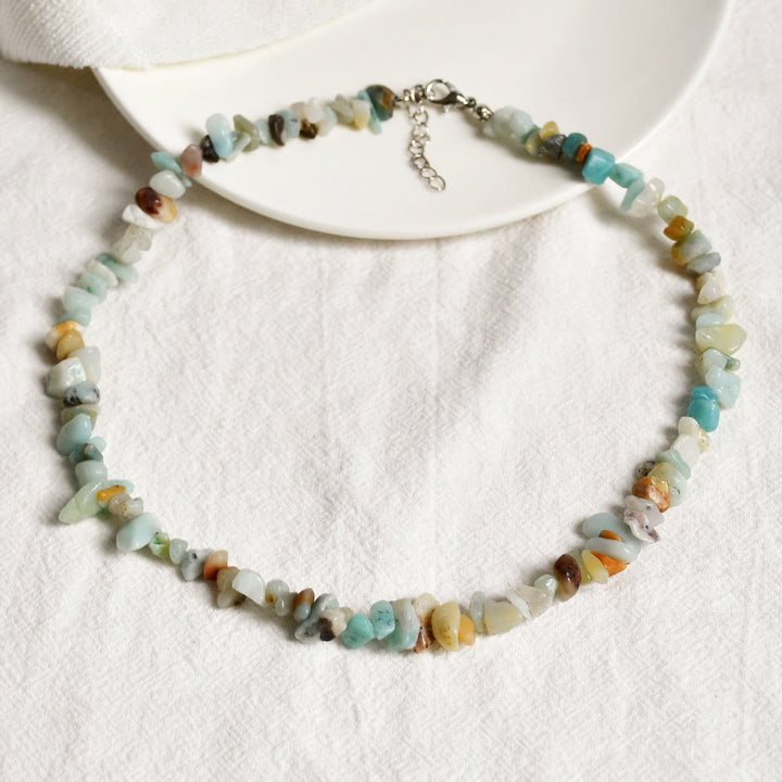 Halskette aus bunten Edelsteinen, handgefertigt, auf weißem Hintergrund, Schmuck für Damen.