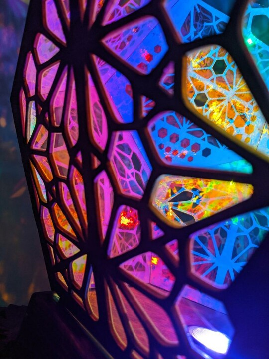 Buntes LED-Nachtlicht mit geometrischem Muster, Holzrahmen, stimmungsvolle Beleuchtung.