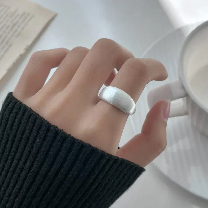 Silberner Ring an Hand, minimalistisches Design, eleganter Schmuck, Damenmode, Nahaufnahme.