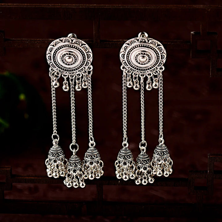 Silberne, lange, indische Ohrringe mit filigranen Details und hängenden Anhängern.