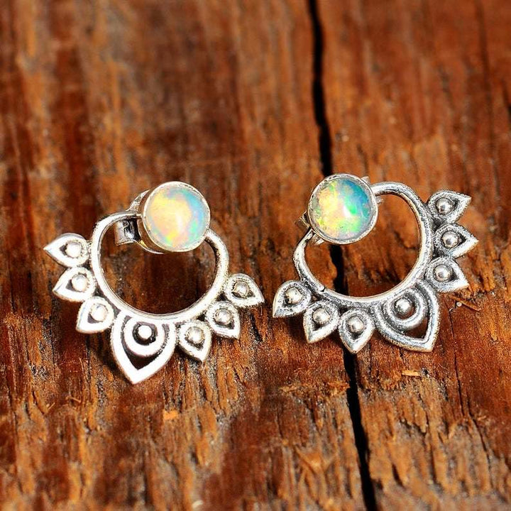Silberne Ohrringe mit Opal, Boho-Stil, handgefertigt, Vintage-Design, Holz-Hintergrund.