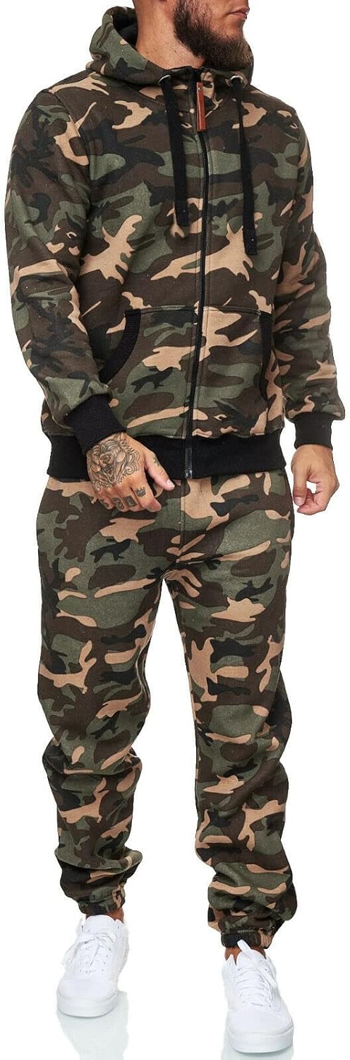 Mann in Camouflage-Trainingsanzug mit Kapuze, Reißverschluss und weißen Sneakers.