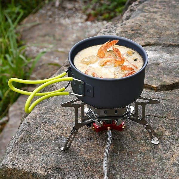 Campingkocher mit Topf, Suppe und Garnelen, Outdoor-Kochen, tragbar, robust, kompakt.