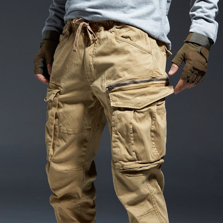 Beige taktische Cargohose mit mehreren Taschen und Reißverschlüssen, ideal für Outdoor-Aktivitäten.