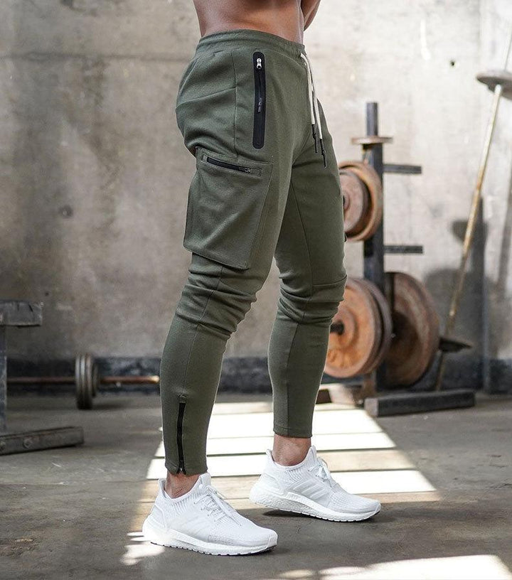Grüne Jogginghose mit Taschen, Reißverschlüssen, sportlich, Herrenmode, Fitnessstudio, bequem.