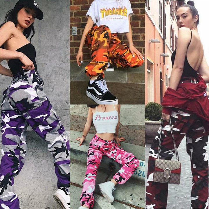 Vier Frauen in bunten Camouflage-Hosen: lila, orange, pink, rot. Streetwear, modisch, urban.