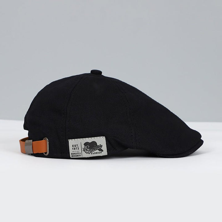 Schwarze Schiebermütze aus Baumwolle mit Lederband, stilvoll und zeitloses Design.