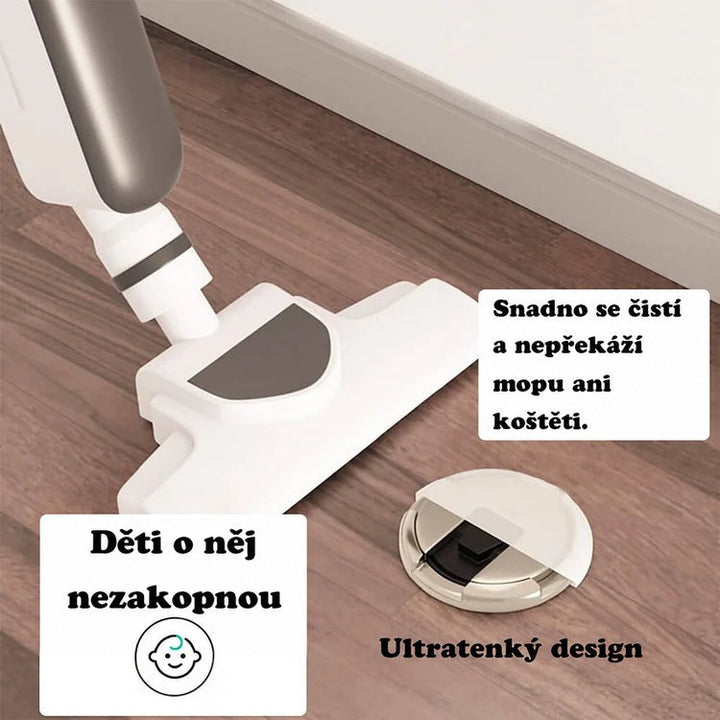 Tenký kulatý doraz na dřevěné podlaze vedle bílého vysavače, ukázka snadného úklidu kolem něj 2