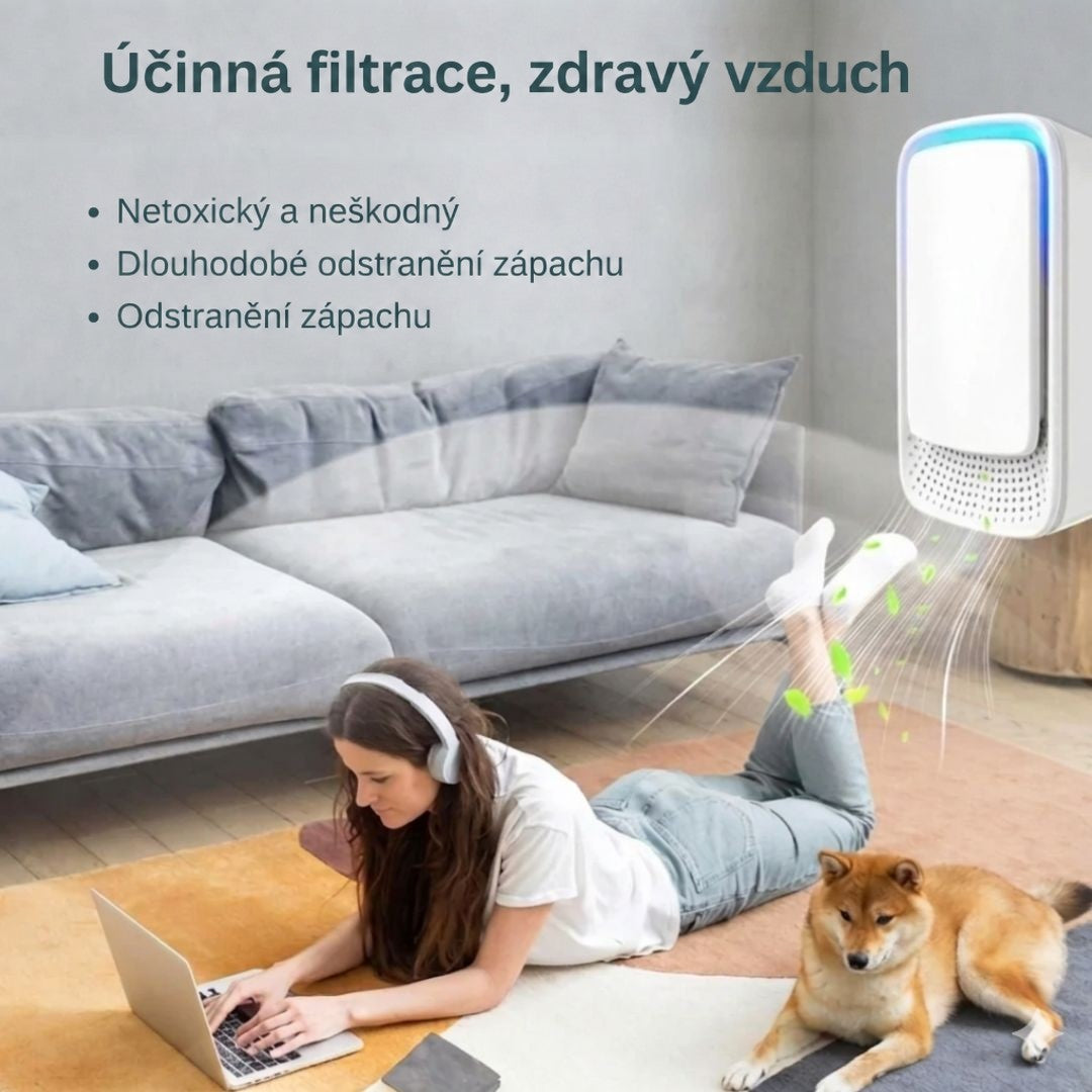 Žena s notebookem leží na koberci v obýváku, nad ní proudí vzduch z ionizátoru, vedle pes 7